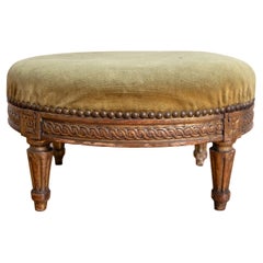 Francese, periodo Luigi XVI, poggiapiedi intagliato in legno dorato e imbottito, 1780 ca.