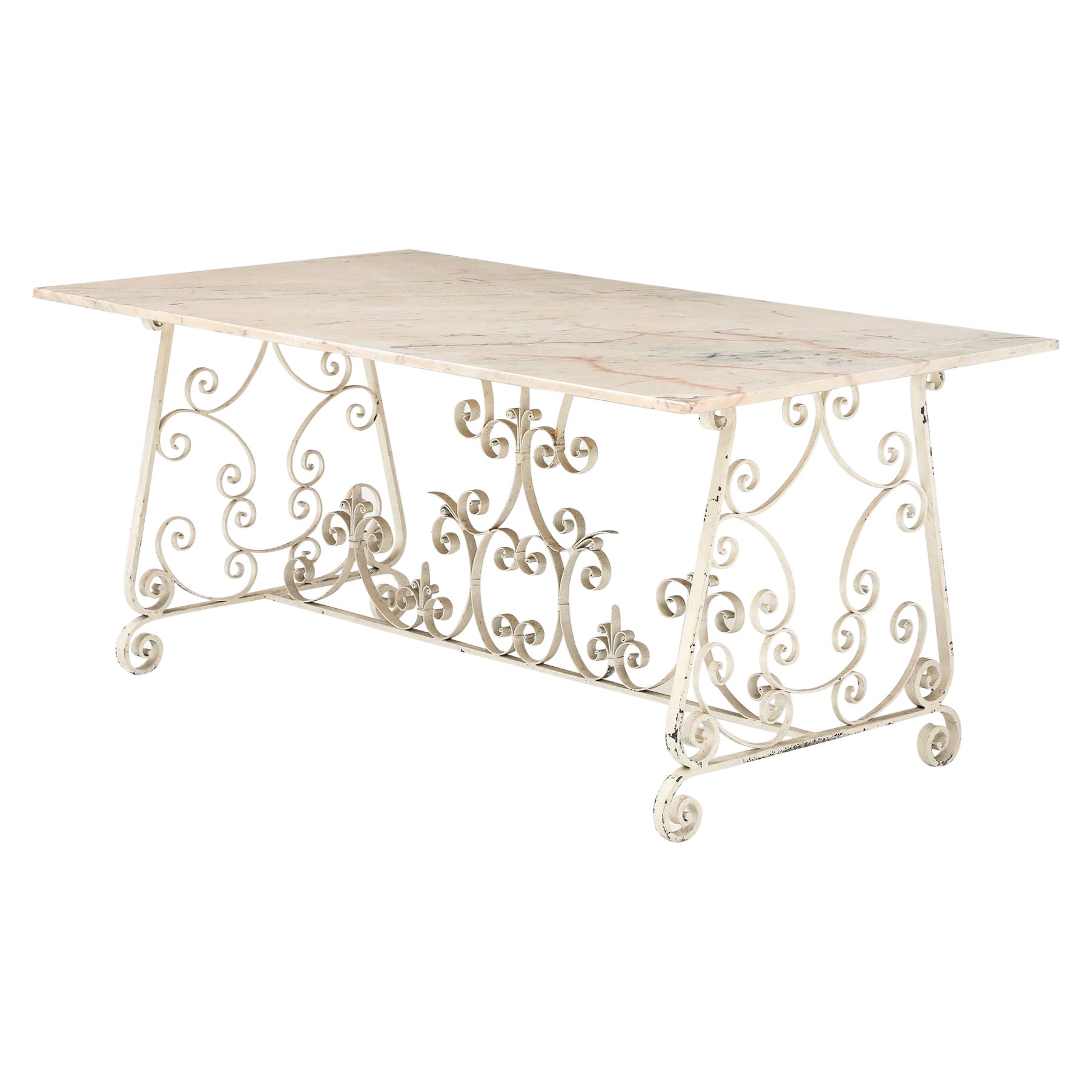 Table de salle à manger à plateau de marbre et base métallique à décor de volutes, Angleterre, milieu du 20e siècle.