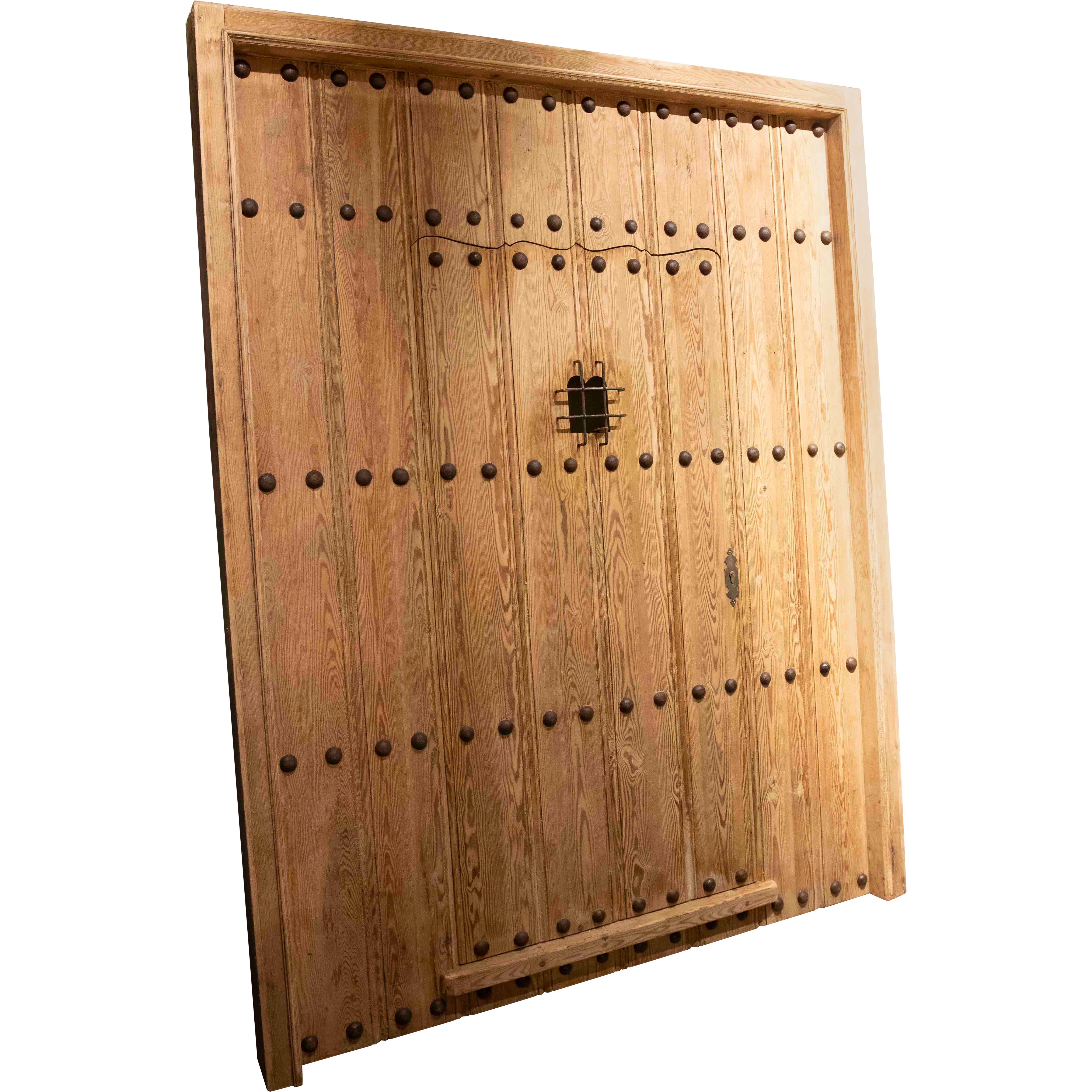 Puerta rústica española de madera de los años 50 con clavos forjados y reja central de hierro en venta