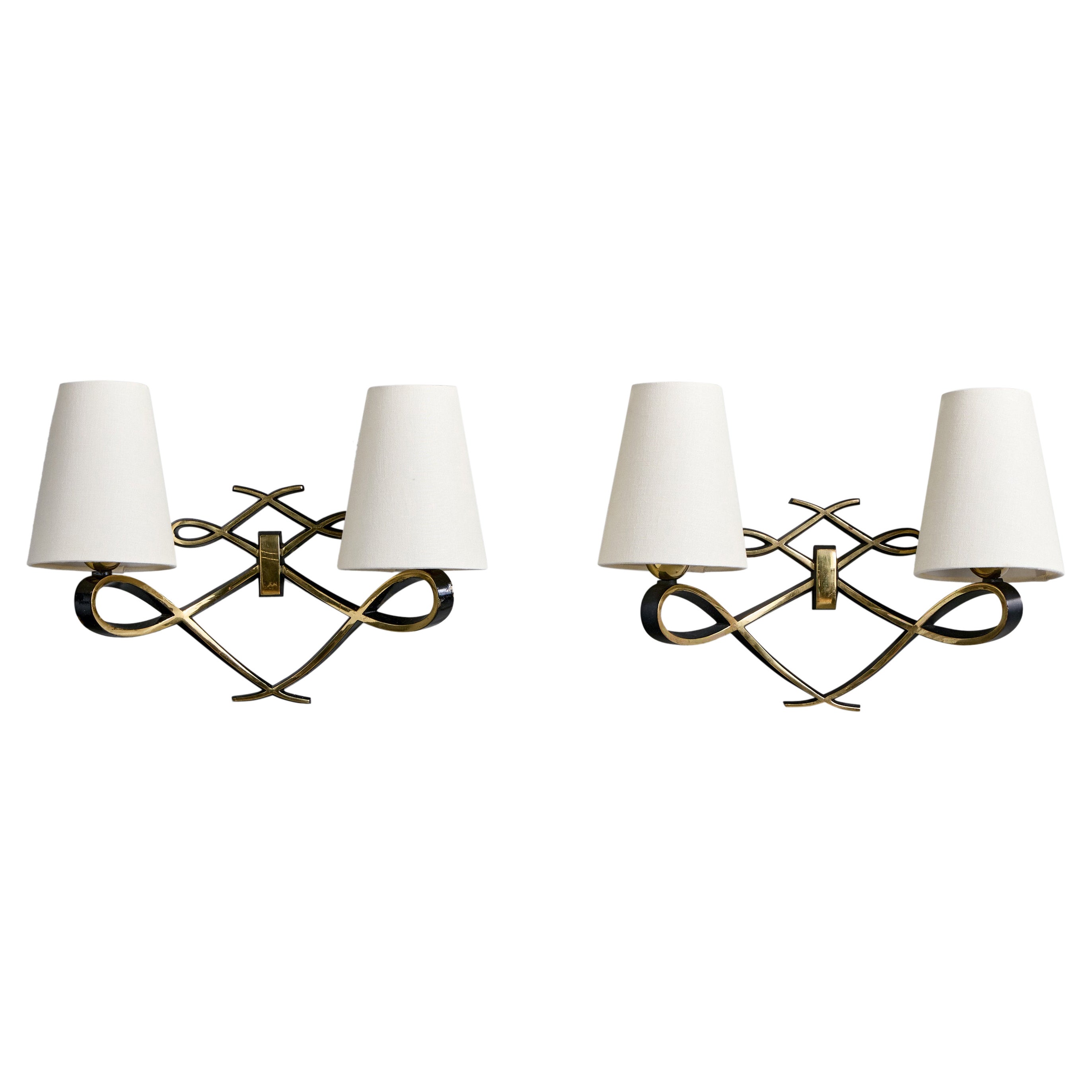 A pair of black-lacquered brass and white fabric wall lights designed and produced in Italy, c. 1930s.

Minor wear to edges of one fixture just below the sockets.

Overall Dimensions (Inches): 10.75” H x 15.25” W x 5” D

Bulb Specifications: