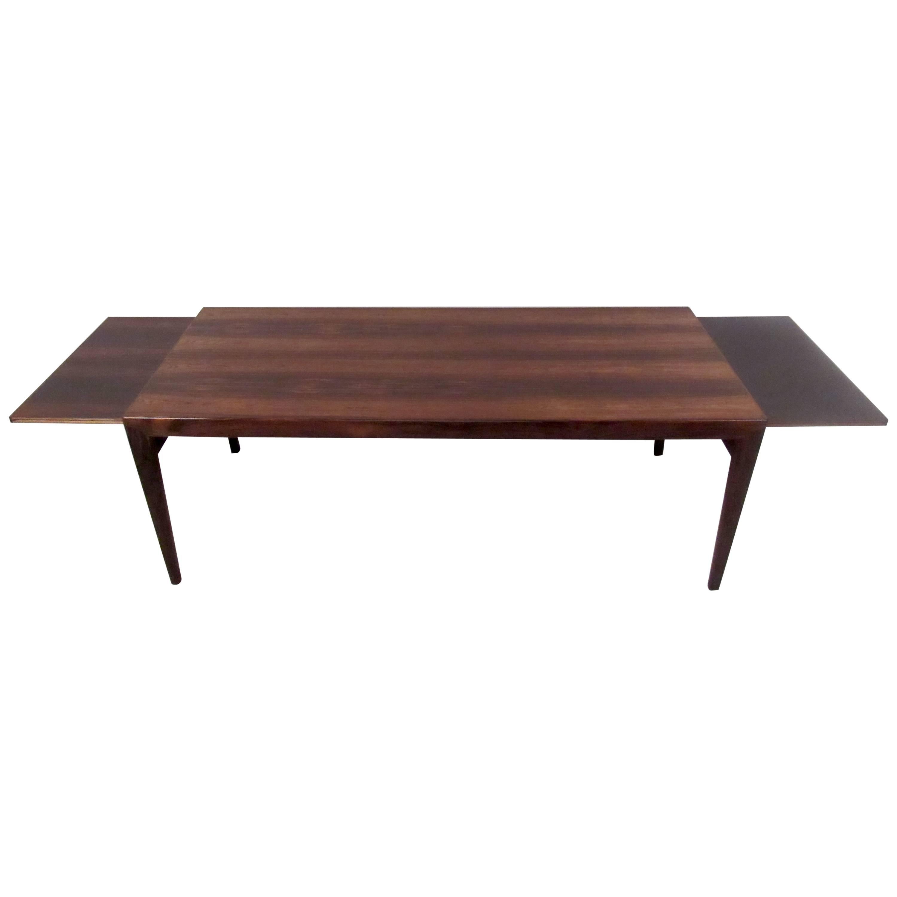 Vintage-modern coffee table featuring two-draw leaves and beautiful rosewood grain, designed by Johannes Anderson.

