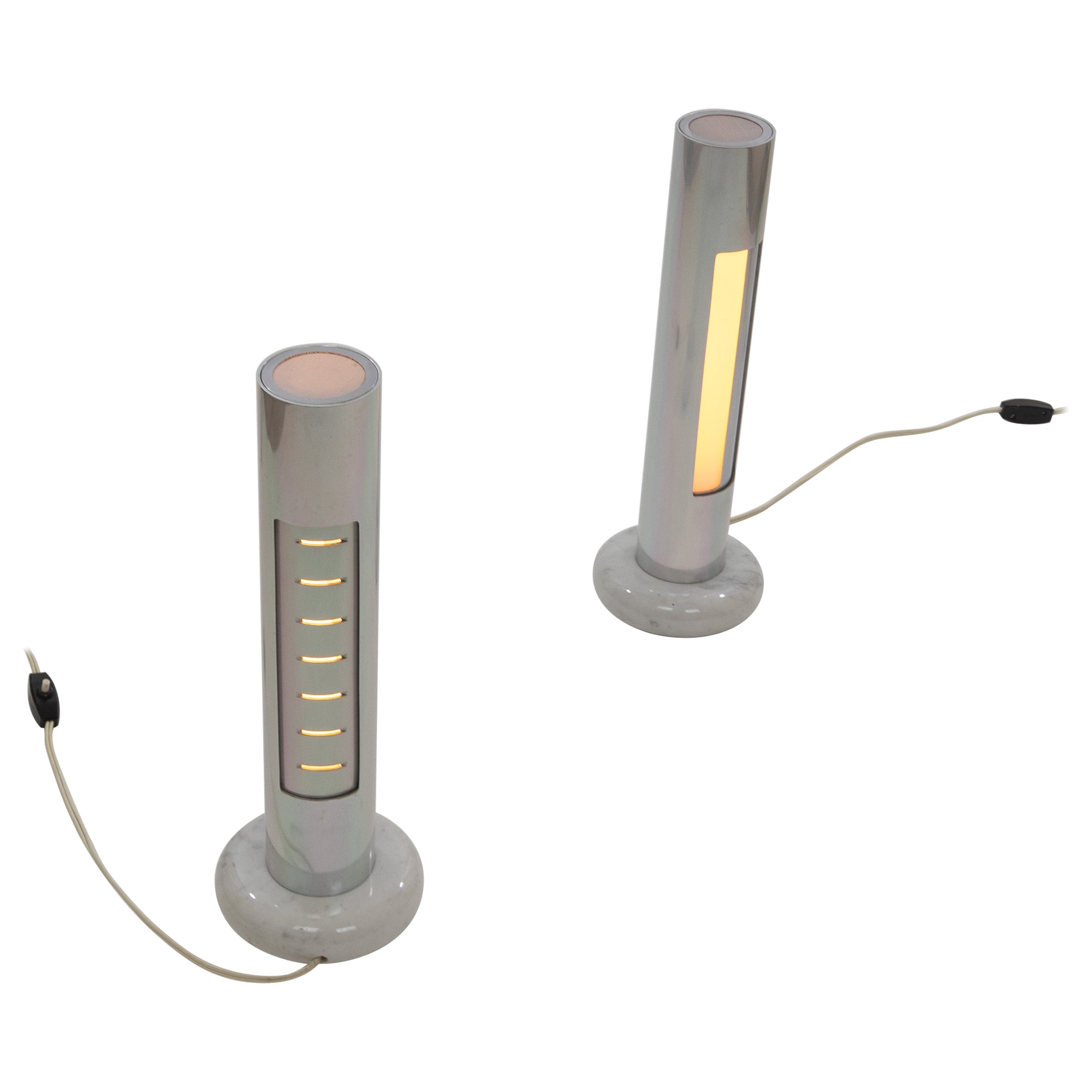 A pair of Morgana table lamps designed by Enrico Panzeri and produced by Nucleo Sormani in 1971.

Table lamp consisting of two anodised aluminum cylinders on a veined white marble base. The inner cylinder has a large vertical aperture with white