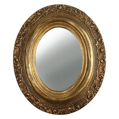 French Baroque style oval mirror in gilded wood with floral decorations