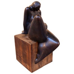 Escultura contemporánea de los años 70 de una figura femenina en bronce sobre una base de madera