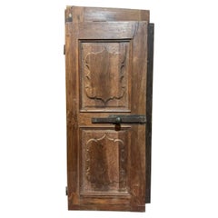 Puerta interior de madera de nogal, de una hoja con paneles ondulados tallados, Italia