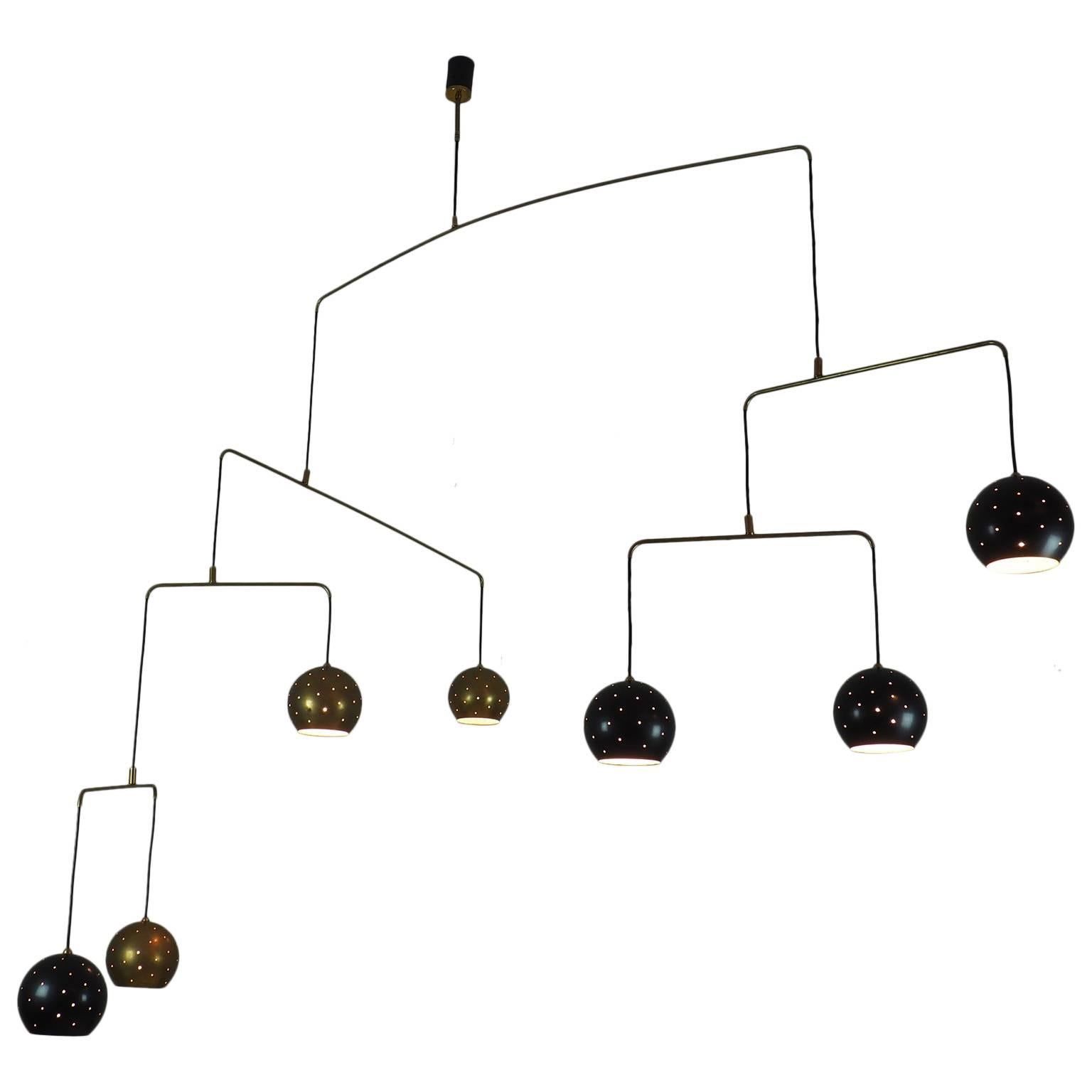 The   ITALIAN vintage   Mobile chandelier.
Large magic and poetic  Mobile chandelier with brass and black suspending spheres that move with the flow of air.
Wholly in balance through brass arms and the interaction of the weights of the balls and