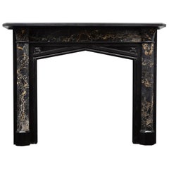An antique Gothic revival, black marble and portoro marble mantel