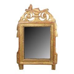 Miroir de style Louis XVI encadré de feuilles d'or, 19e siècle, avec écusson à thème musical