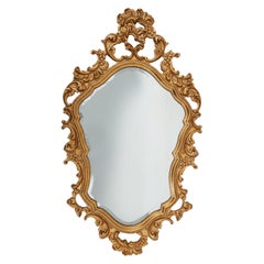 French Rococo or Baroque style facet-cut crest mirror in gilded carved wood