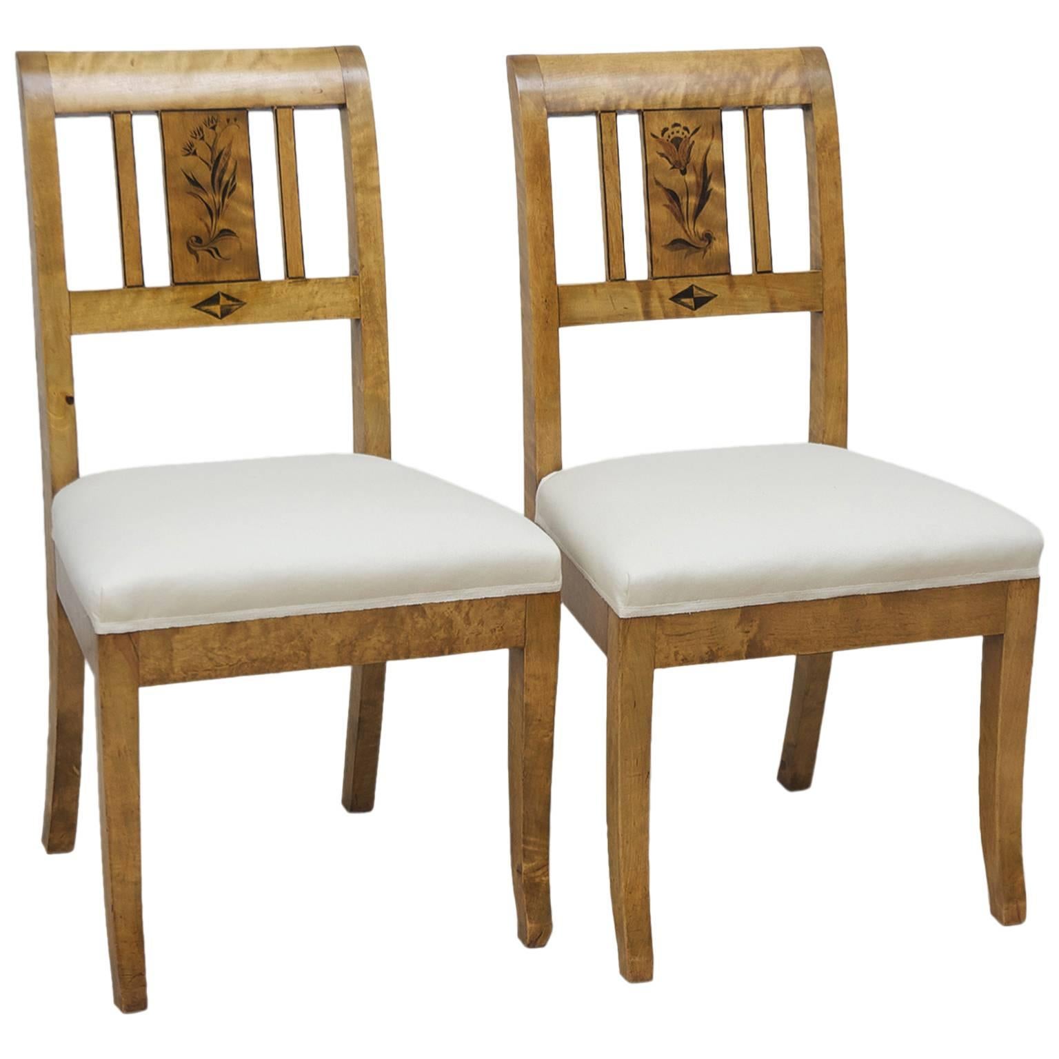 A pair of comfortable Swedish Art Deco side chairs in birch with black stenciled flowers on back-splat, square saber front and back legs and upholstered seat. Signed C. J. Svensson, Goteborg, 1925.
Note: Chairs have been re-upholstered in a Lee