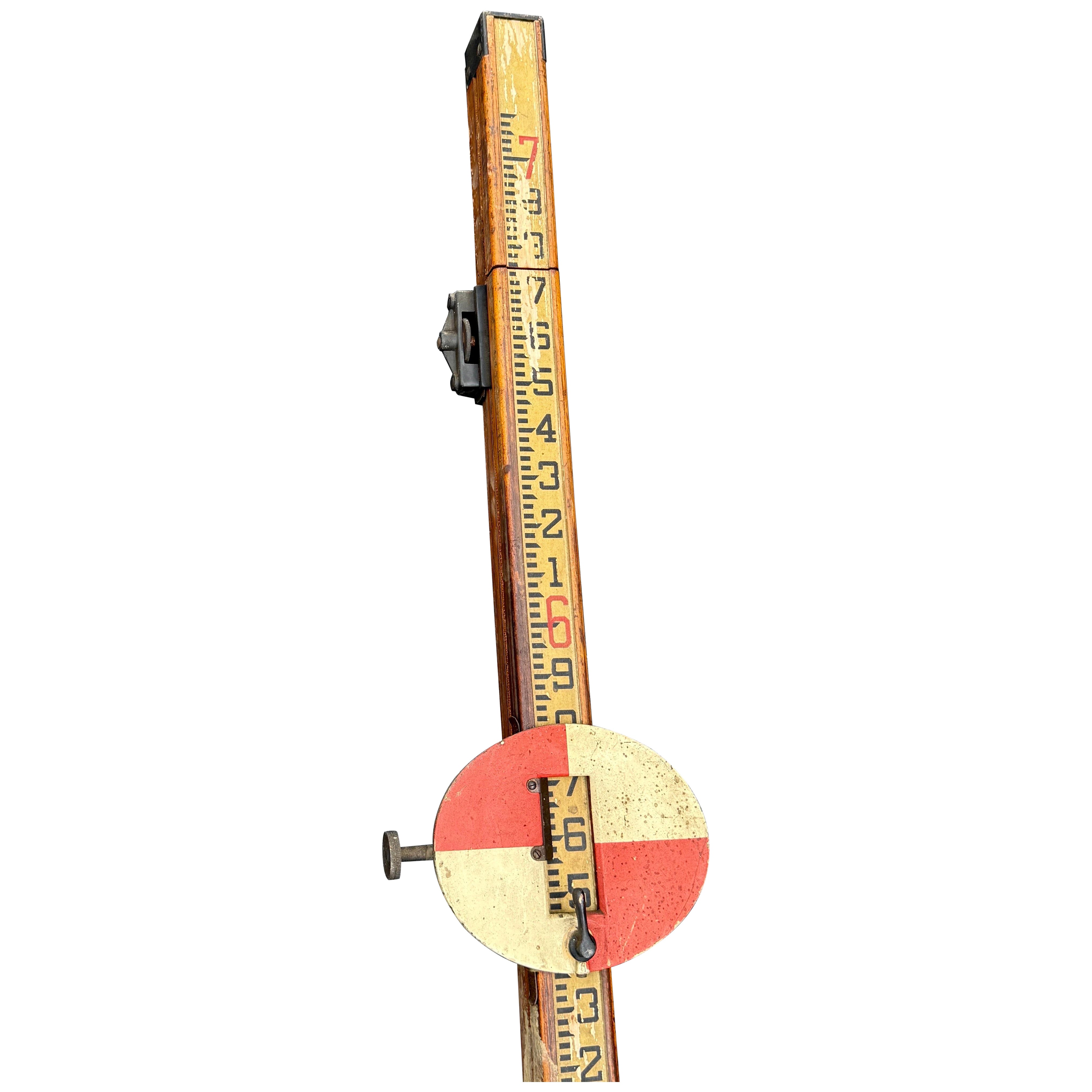 Vintage surveyors rod with a circular target from Keuffel and Esser. This type of instrument is used in land surveying to to measure elevations. The red and white circular target is used to site the rod with a leveling instrument or theodolite. The