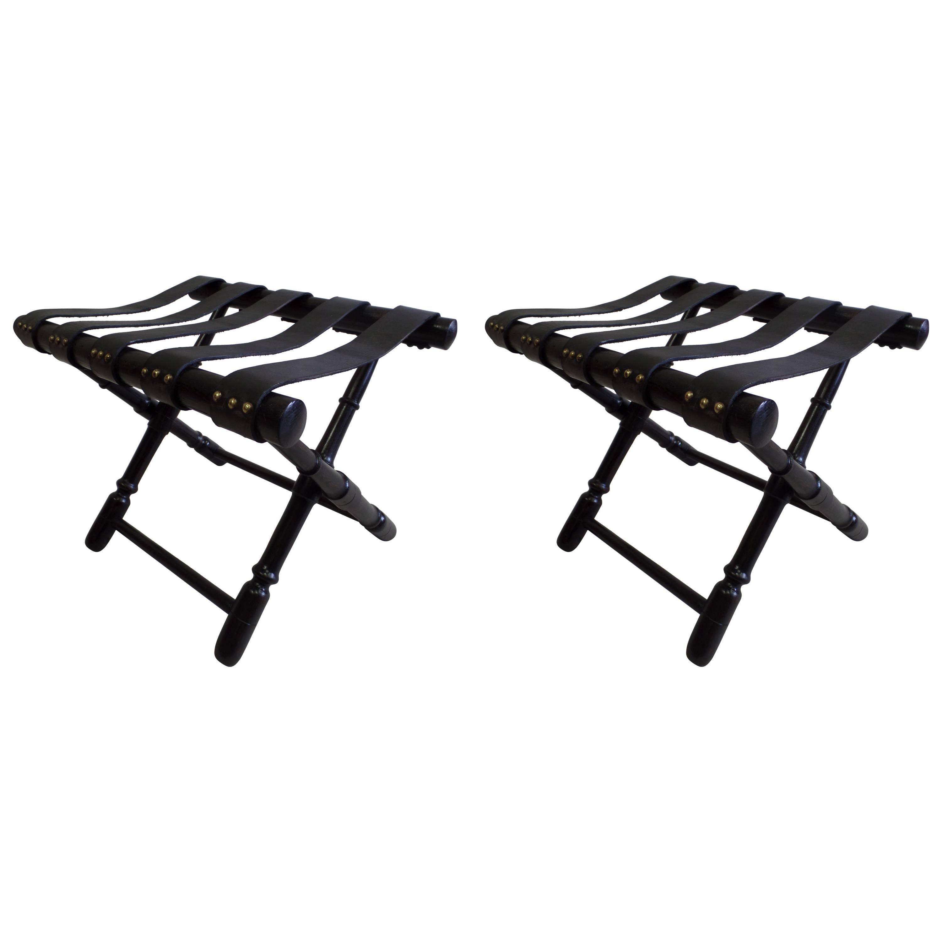 Elegant pair of French Mid-Century Modern neoclassical benches, stools or luggage stands in delicately carved and ebonized wood with the bases arranged in a stunning X-form. The seats / tops are composed of straps of black leather each fixed with