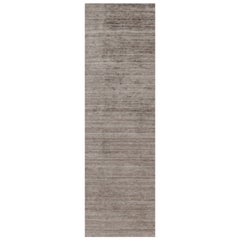 Rug & Kilim è un tappeto oversize con toni solidi beige-marrone e striature.