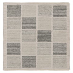Rug & Kilim è un tappeto quadrato e kilim in stile scandinavo con motivi geometrici grigi.