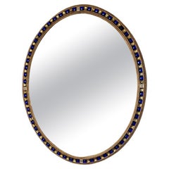 Un site  Miroir mural ovale en bois doré du 19ème siècle avec des bijoux en verre bleu et doré