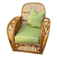 Una grande poltrona Art Deco in rattan con finitura naturale e cuscini Sunbrella color cilantro.