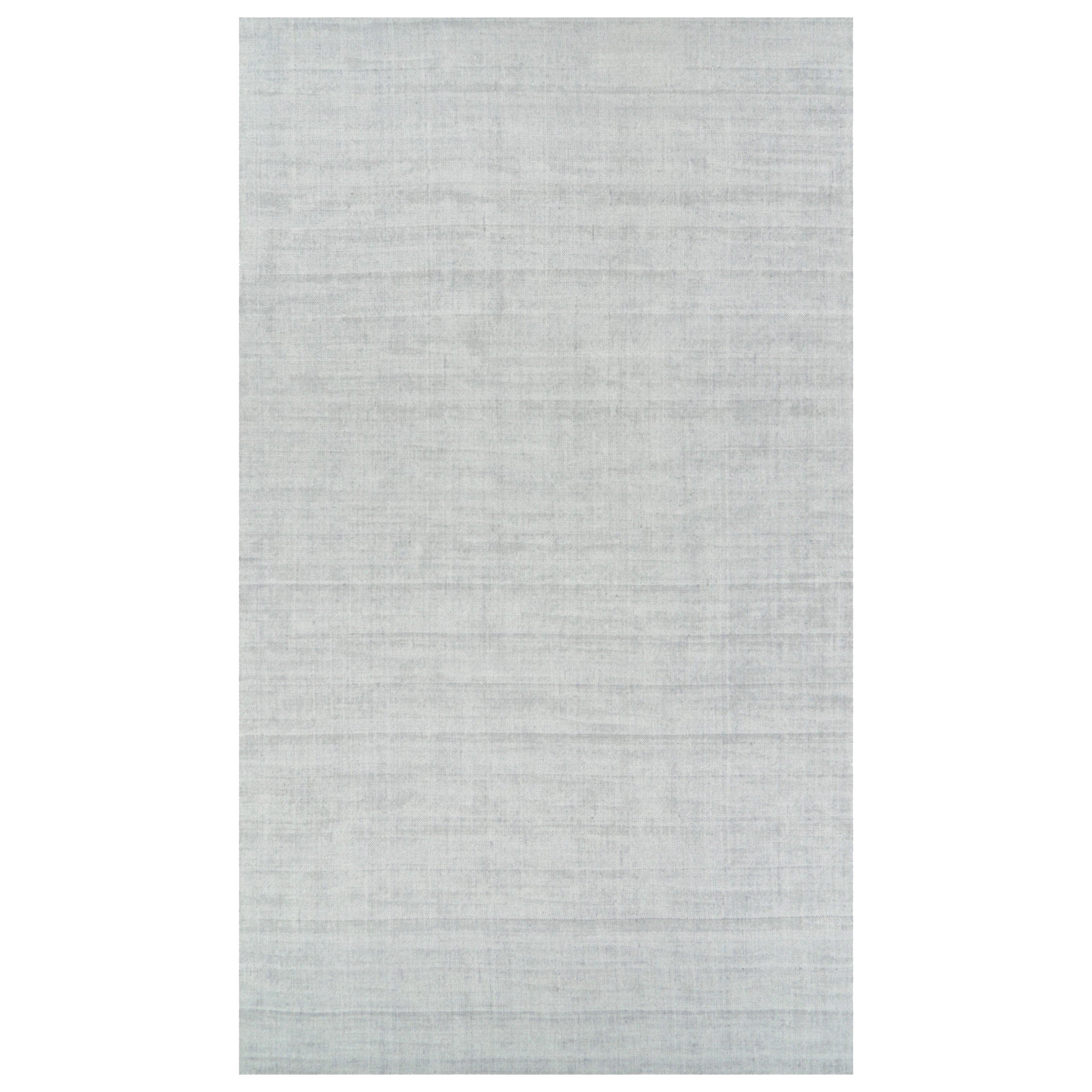 Rug & Kilim è un tappeto oversize dai toni grigio chiaro e blu con striature