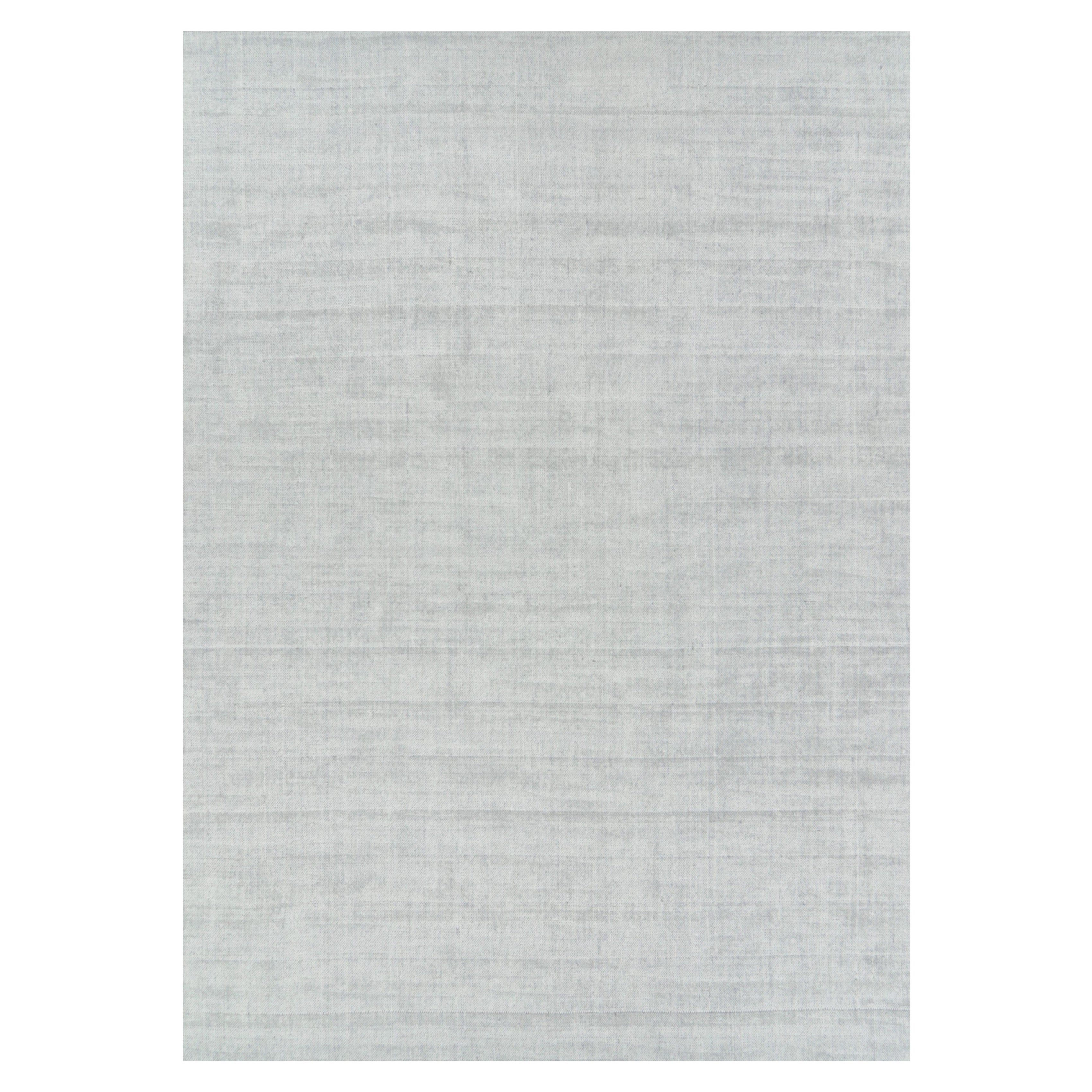 Rug & Kilim è un tappeto oversize dai toni grigio chiaro e blu con striature