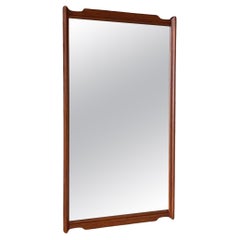 Miroir mural en noyer sculpté de style moderne du milieu du siècle.