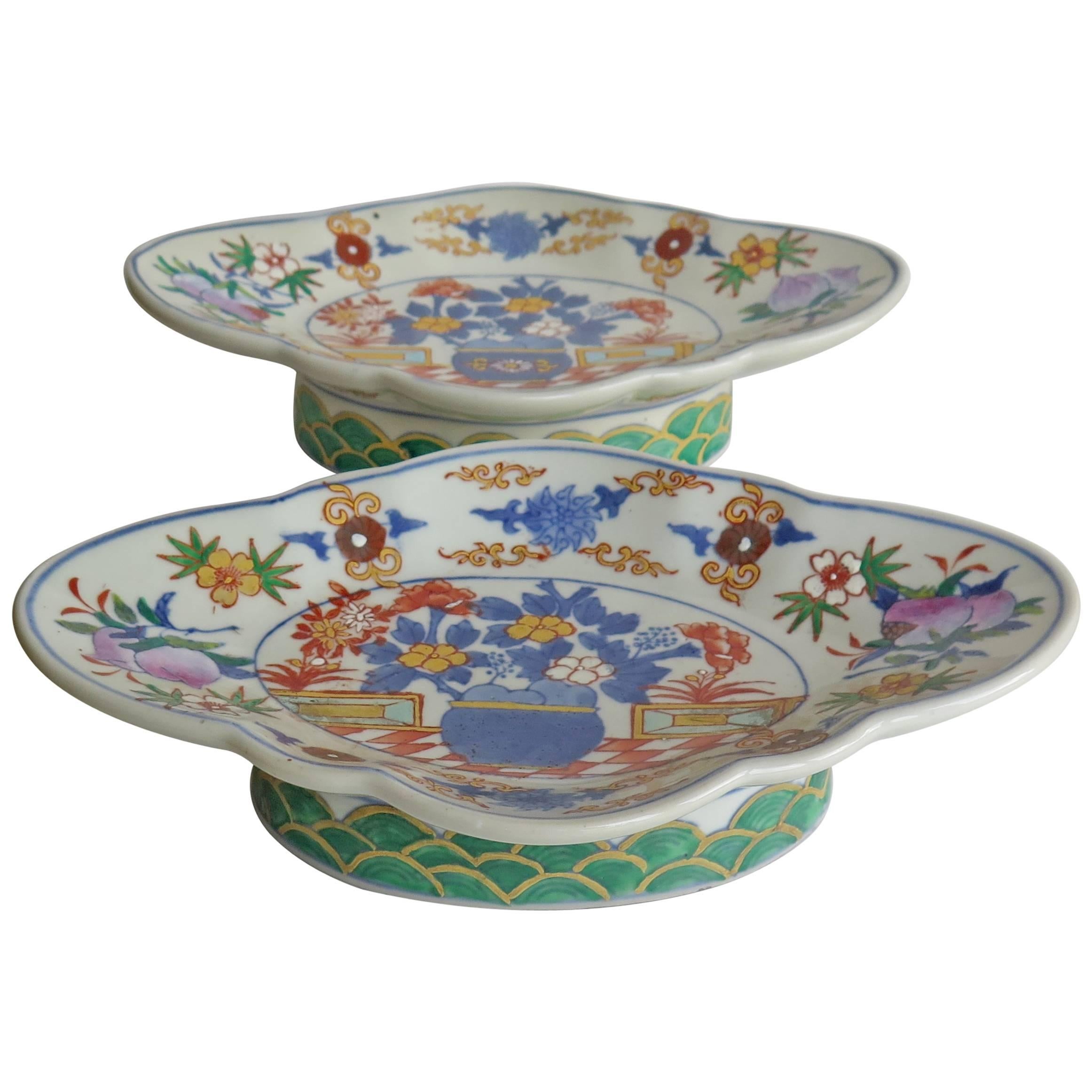 These are a very decorative pair of Chinese Export porcelain footed fruit bowls or dishes.

Each oval bowl is shallow with a serpentine scalloped edge, raised on a deep oval foot which is slightly splayed. They are decorated in an under-glaze blue