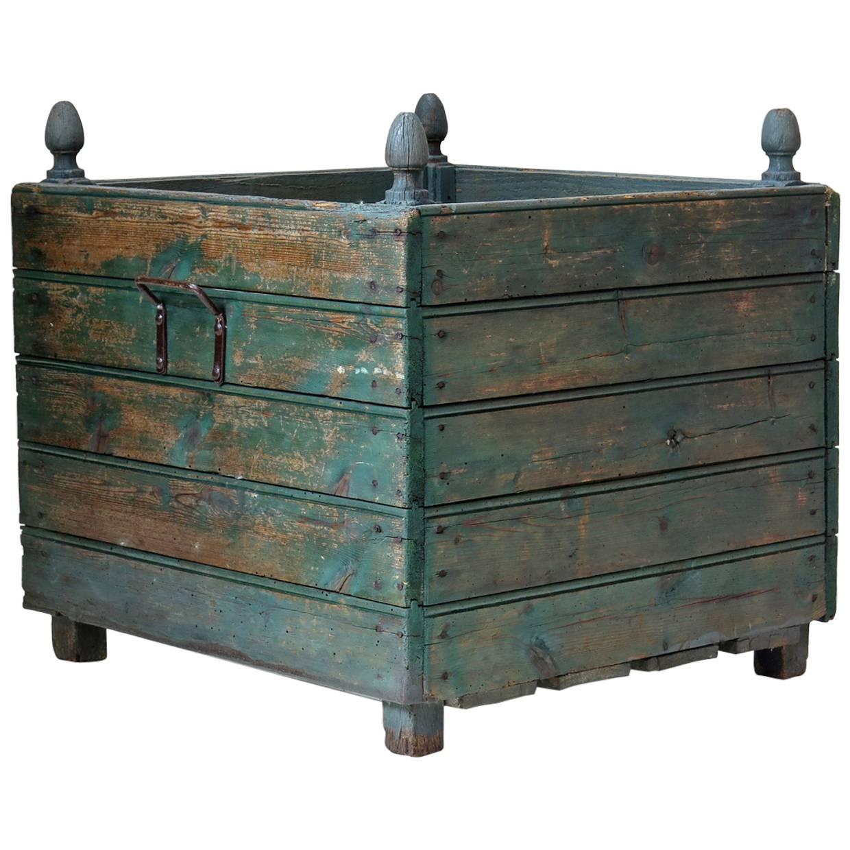 Elegant pair of large square wooden box planters, painted green with finials at each corner.