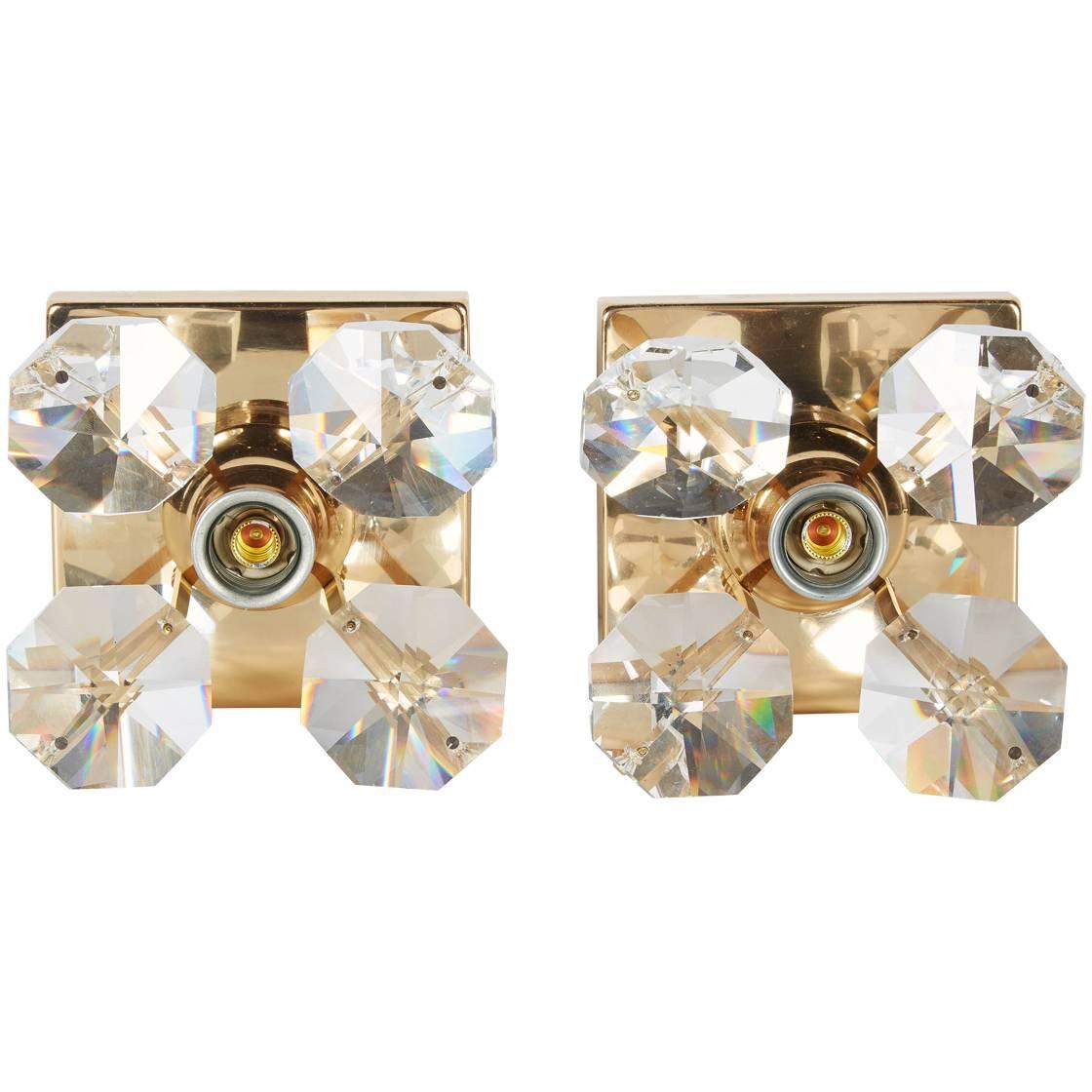 Pair of Mid-Century Modern gold plated sconces with large cut crystals and cylinder stems, creating the form of a flower. Each sconce is fitted with one center light allowing the light bulb of choice to contribute to the floral design. Exquisite and