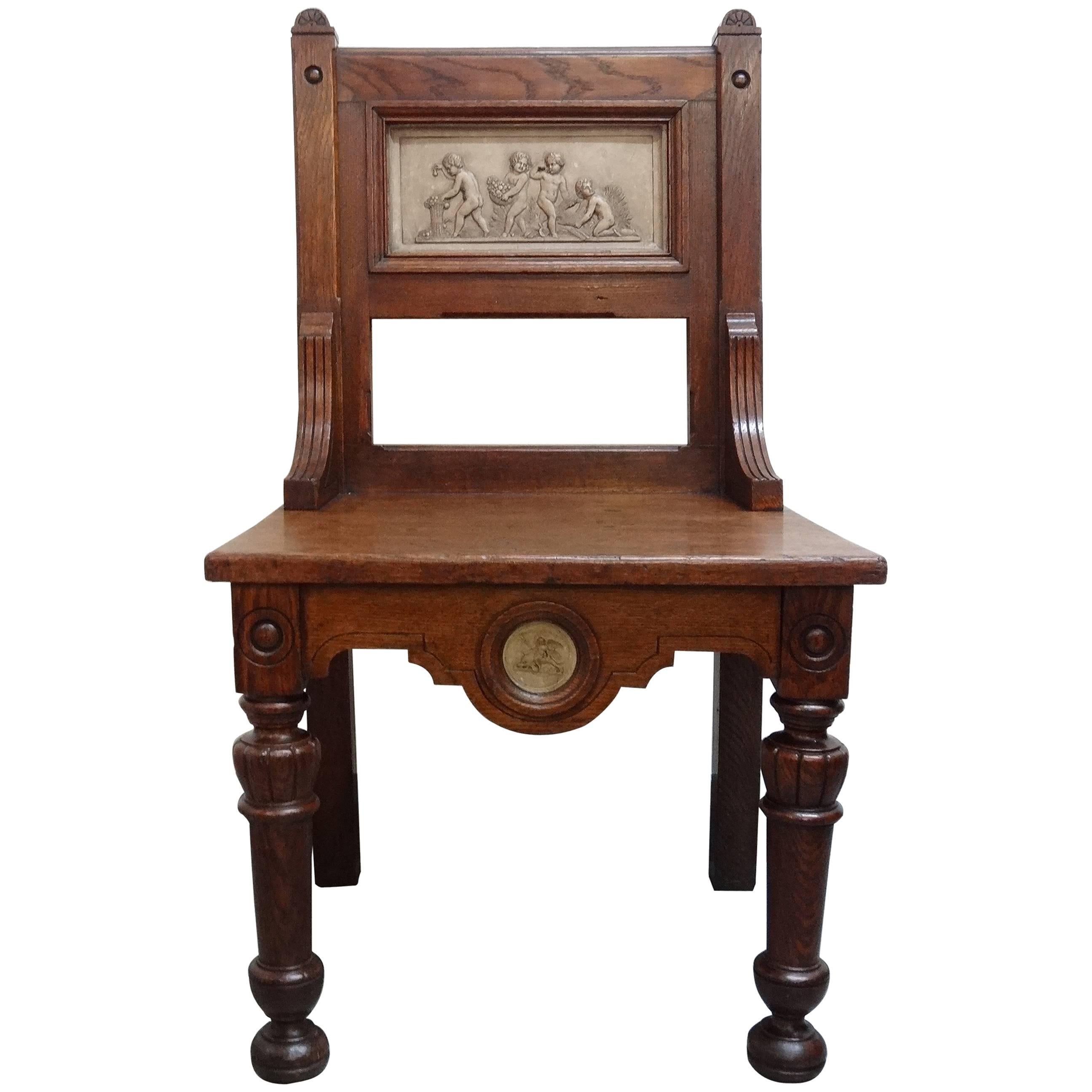 Arts and Crafts Gillows oak hall chair with putti plaster panels circa 1880s For Sale