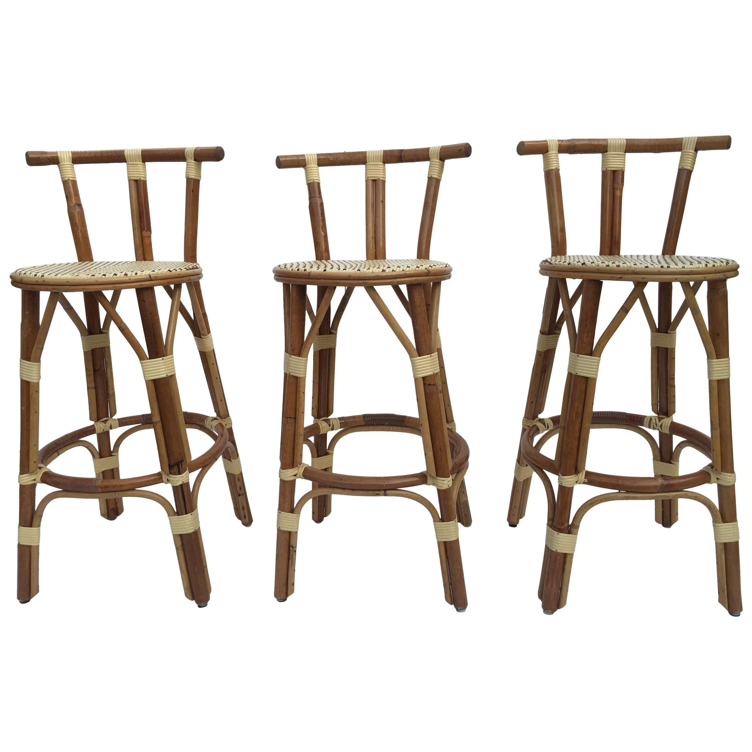 Rattan set of three signed small bar stools by Maison J. Gatti with woven seats, just gorgeous. 
