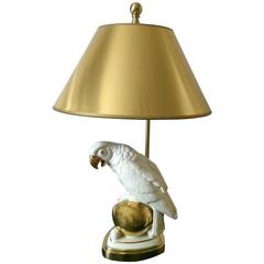 Perroquet en porcelaine sur un globe doré monté comme lampe de bureau