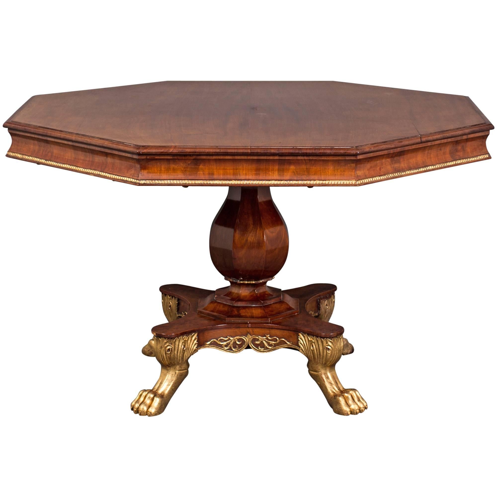 Centre Table Walnut Gilded Details English 19th century Regency England. A dining table made during the Regency period in England. An octagonal top with a gilded beaded edge standing on an octagonal base. Four lions' paw feet in gilded wood. Walnut