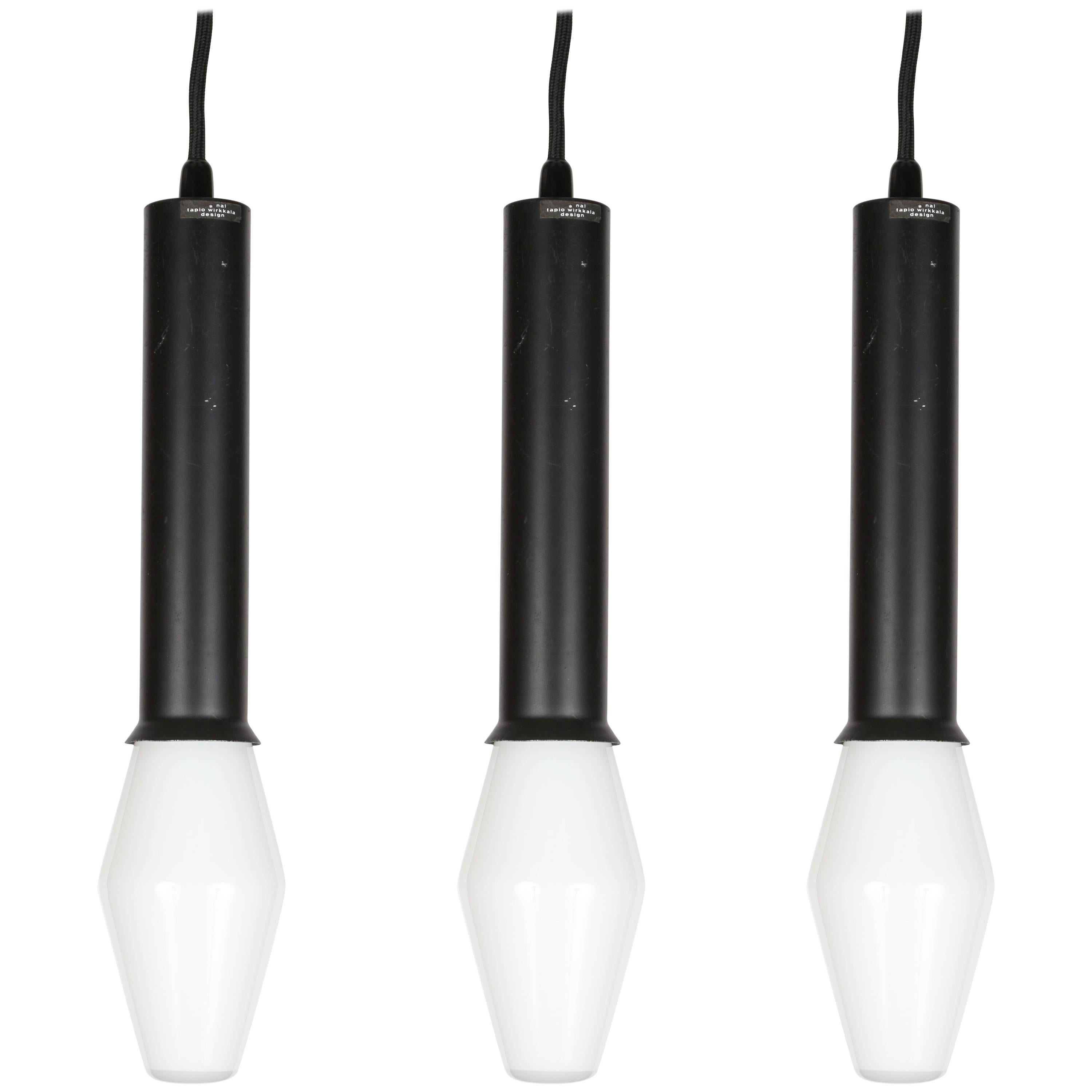 1960s Tapio Wirkkala pendants for Idman, executed in black painted metal and rare blown-glass architectural bulbs. Retains original manufacturer's label and rare original boxes for all three vintage and fully functional bulbs.

Price is for the