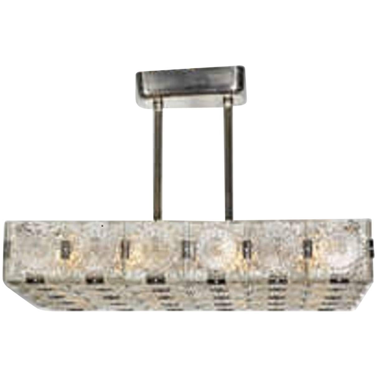 A fabulous rectangular modernist chandelier comprising 44 panels of glass forming a large rectangular shape, supported by a rectangular canopy and fluted double rod stem.
Can be lengthened or shortened for a surcharge. This can be made very short