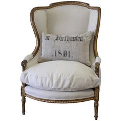 19th Century Louis XVI Giltwood Wing Chair Upholstered in Natural Linen