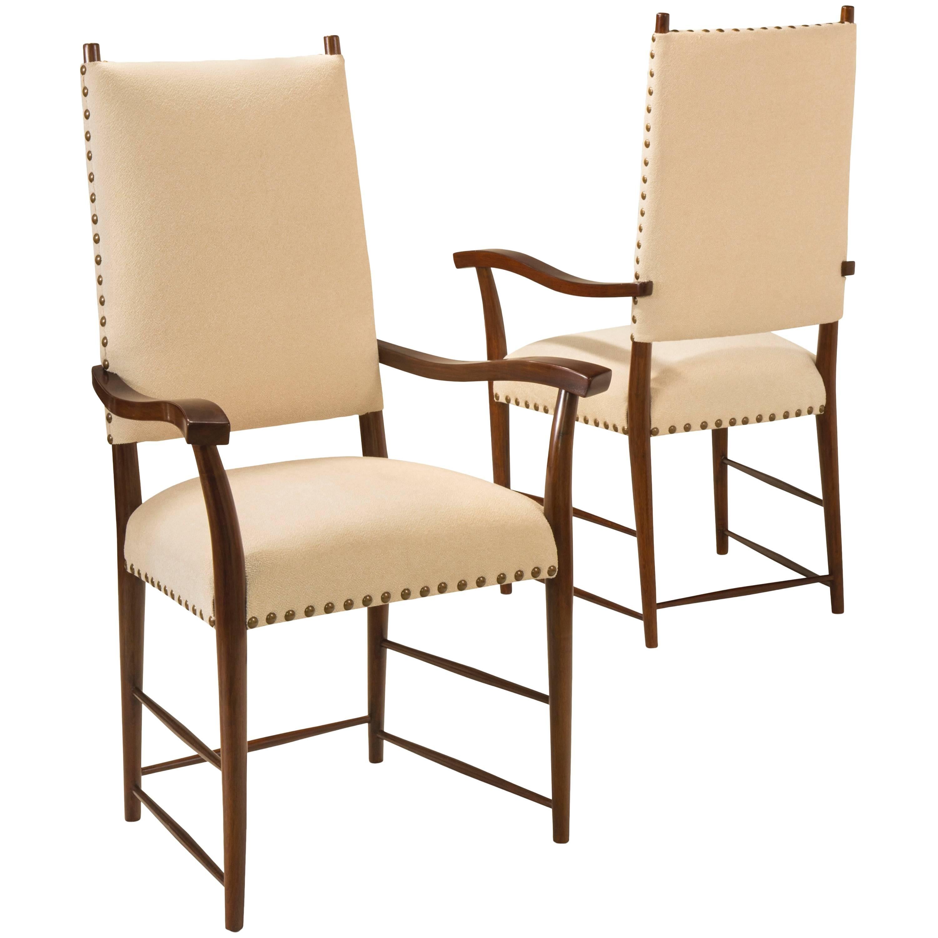 The tall upholstered back above a trapezoidal seat, raised on tapering legs joined by thin, elegant  stretchers. Each ribbon-curved armrest raised on gently bowed supports. Total of 10 side chairs and 2 armchairs available.  