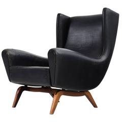 Sillón Illum Wikkelsø "110" de cuero negro y palisandro