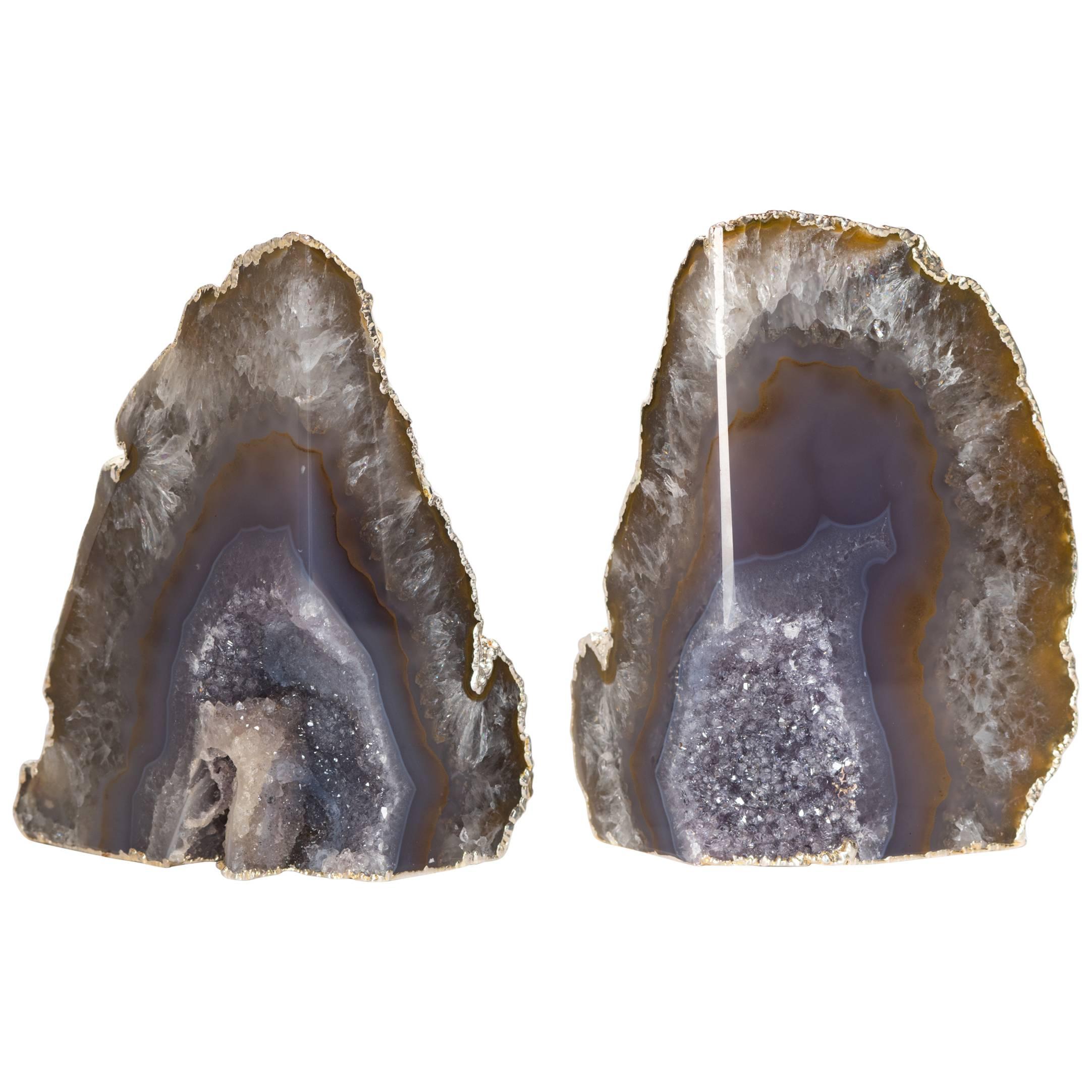 Stunning pair of natural agate stone bookends with fine amethyst crystalline centers. Organic stone with polished fronts with natural rough edges that have been finished in 24-karat white gold electroplating. Can be used in different configurations