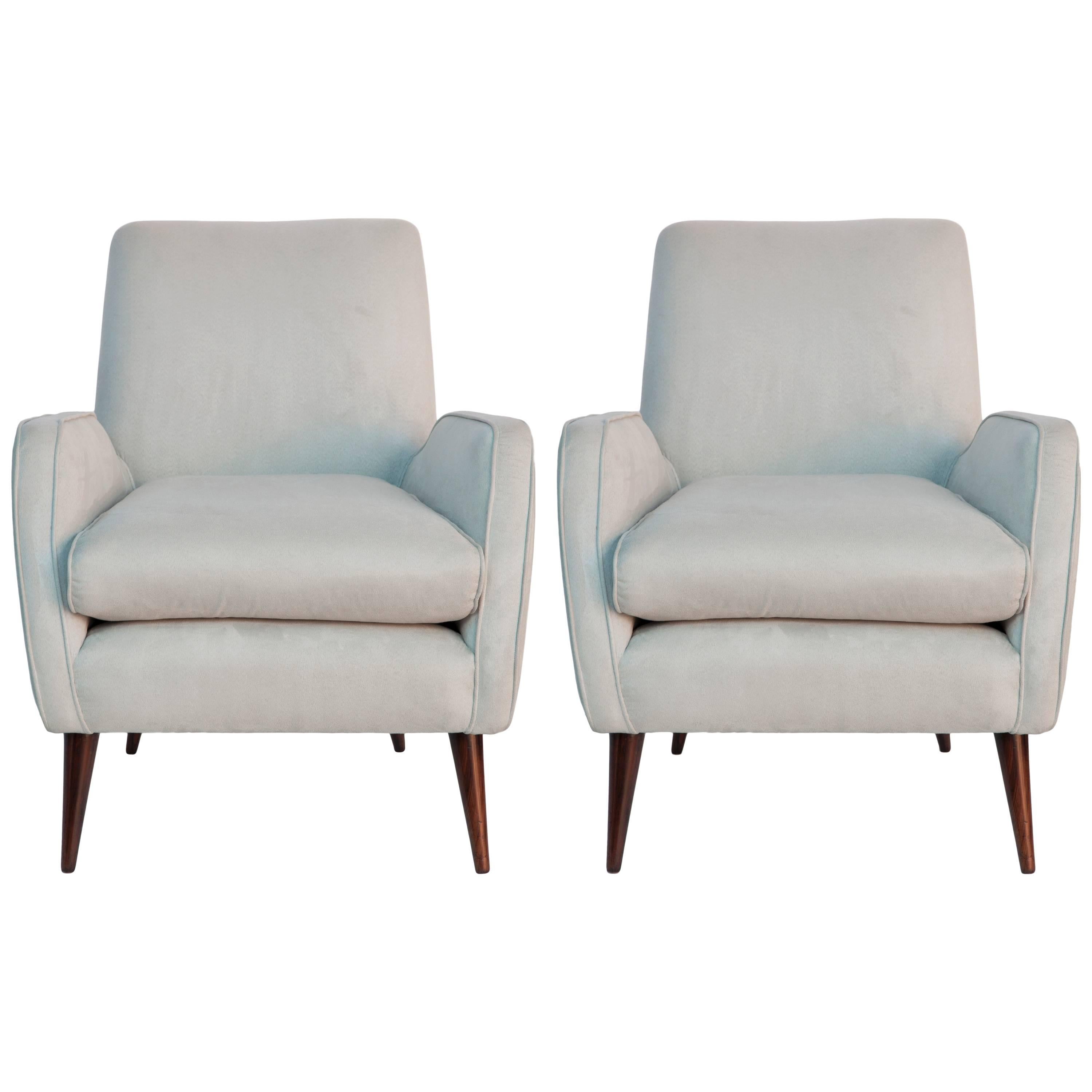 A pair of Mid-Century Modern high back armchairs by Brazilian designer Joaquim Tenreiro, manufactured circa 1960s, upholstered in faux suede, with brass nailhead trim to backs, raised on tapered jacaranda wood legs. Very good vintage condition,