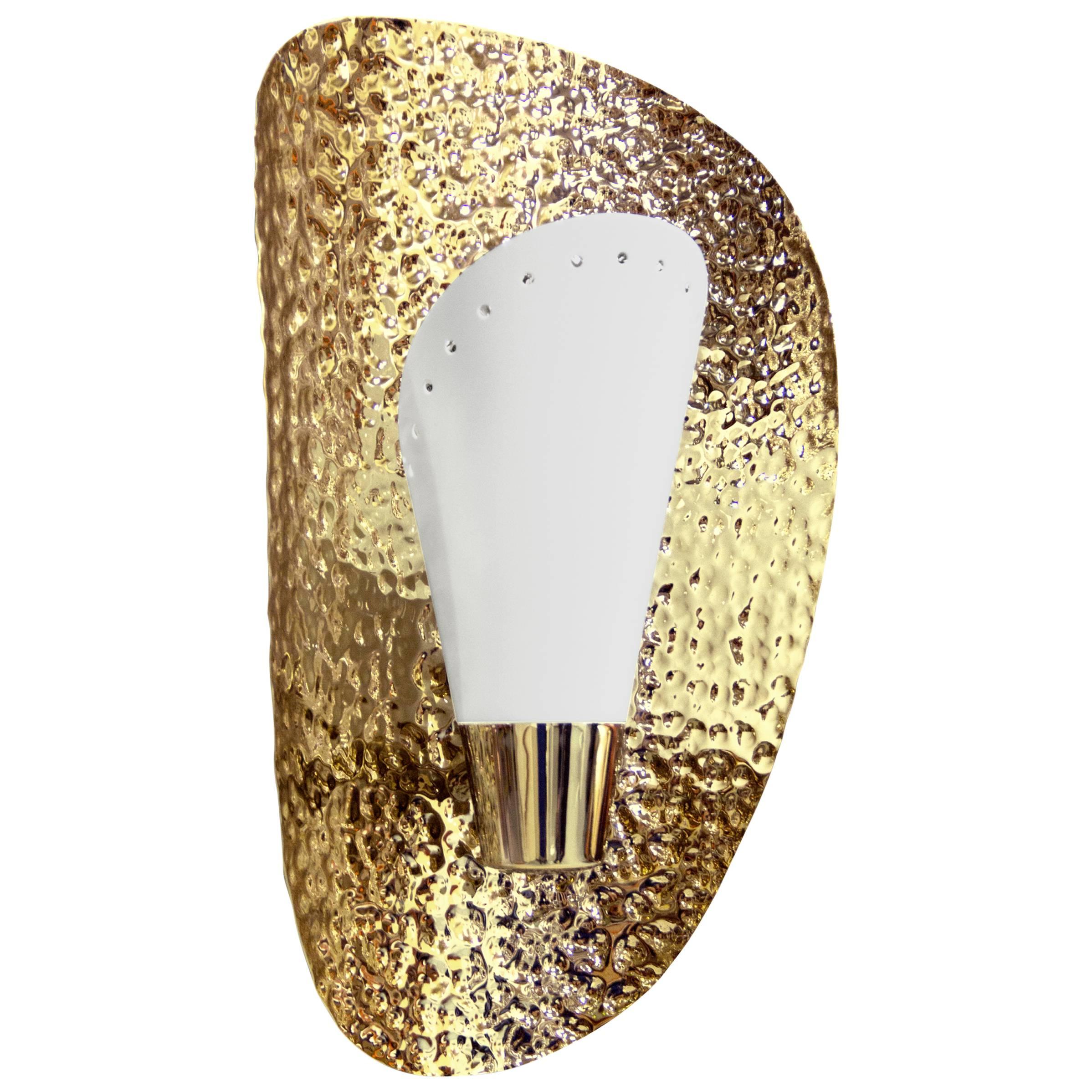 L'ottone riflette la luce a parete come una conchiglia in ottone placcato oro martellato