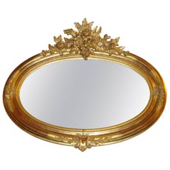Specchio ovale in legno dorato da parete o da camino
