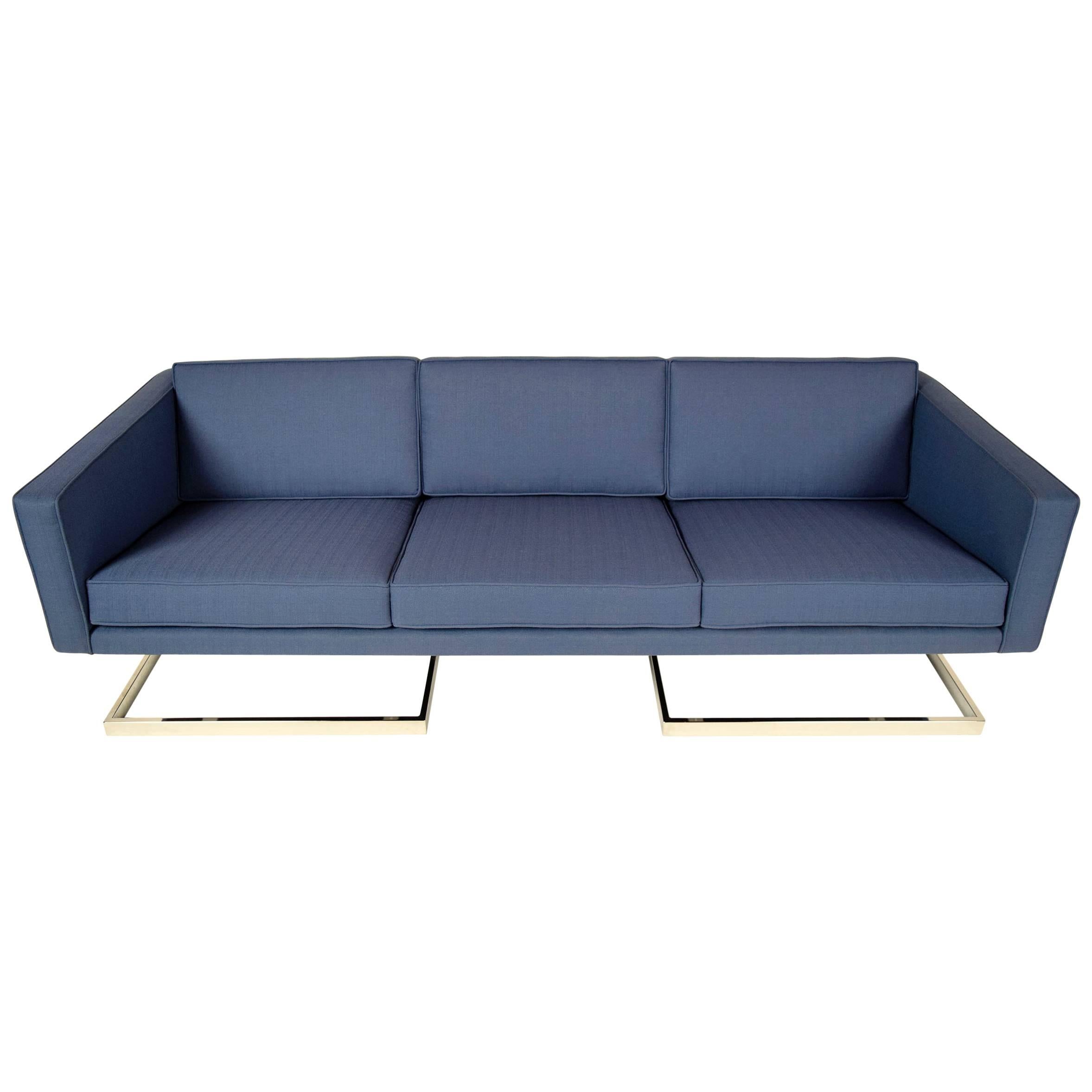 This modern 1960s Milo Baughman style sofa has been professionally reupholstered in a blue fabric with single piping details and features three seating cushions & three loose cushions on the back. This sofa also has new foam inserts that are very