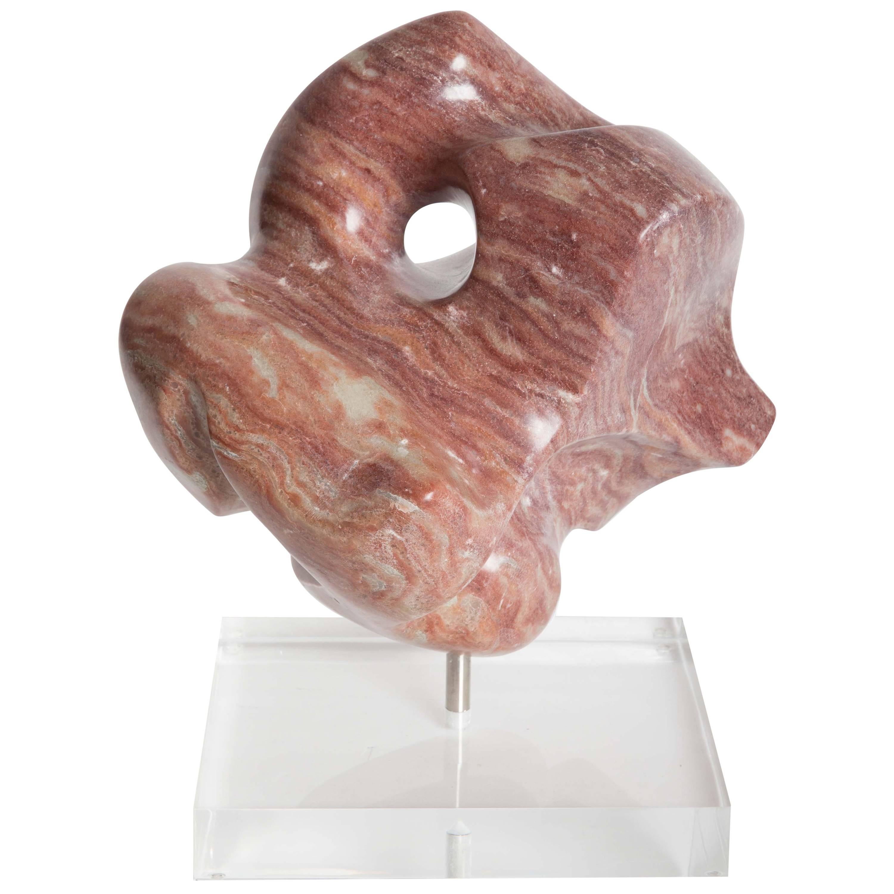 Escultura abstracta de mármol estriado sobre base de lucita