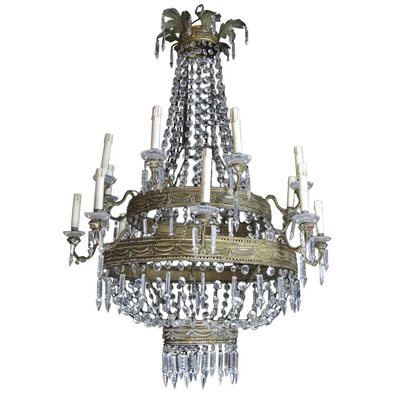 Magnificent antique Empire crystal and gilded brass chandelier, featuring two tiers supporting sixteen arms, dating back to late 18th century of Italian origin, coming from a Tuscan private palazzo in Florence.

The hand-made circular structure