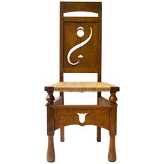 M H Baillie Scott attri An Arts & Crafts Oak Chair With Stylised Floral Cut-Outs