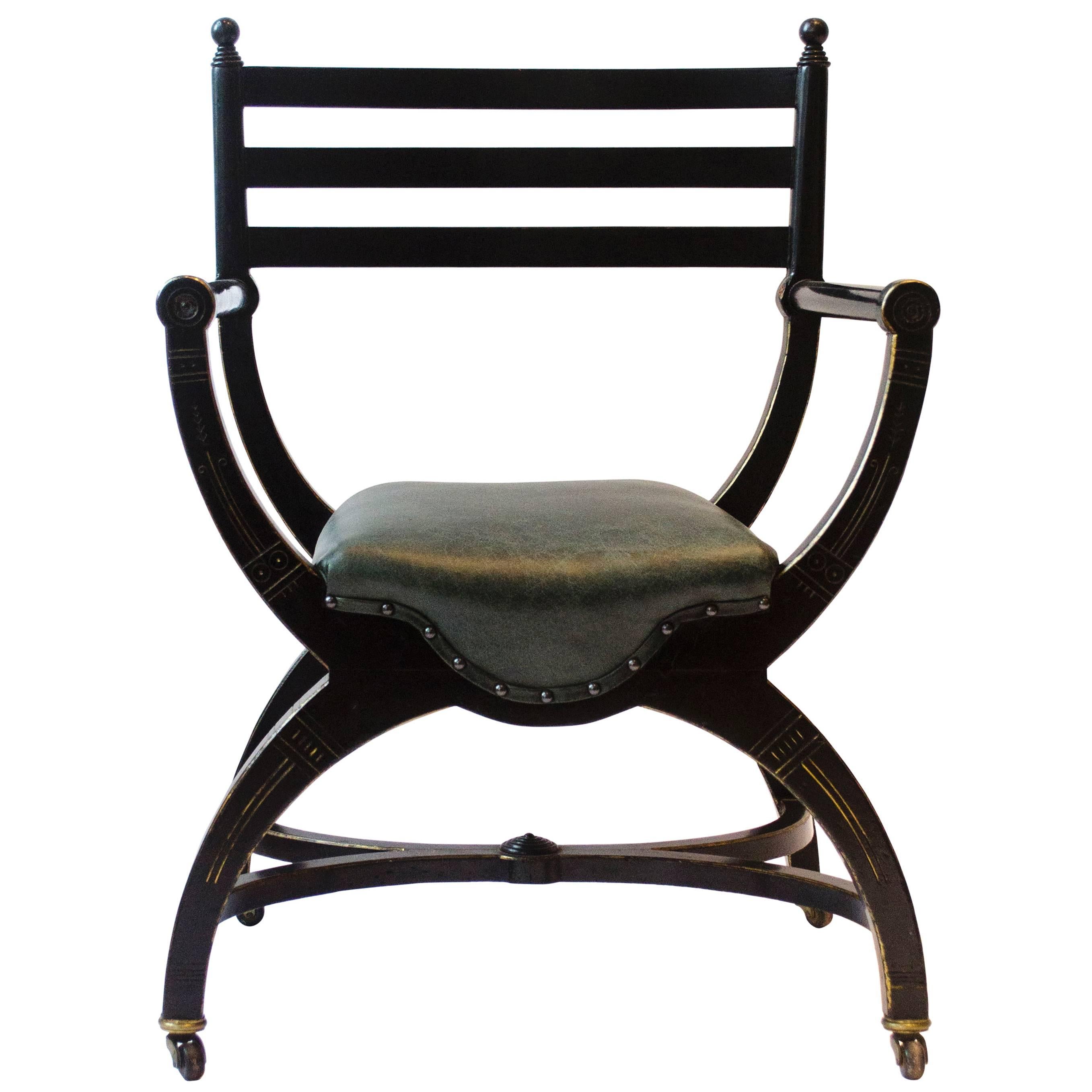 Richard Charles Aesthetic Movement Ebonised Elbow Chair with X Frame stretcher