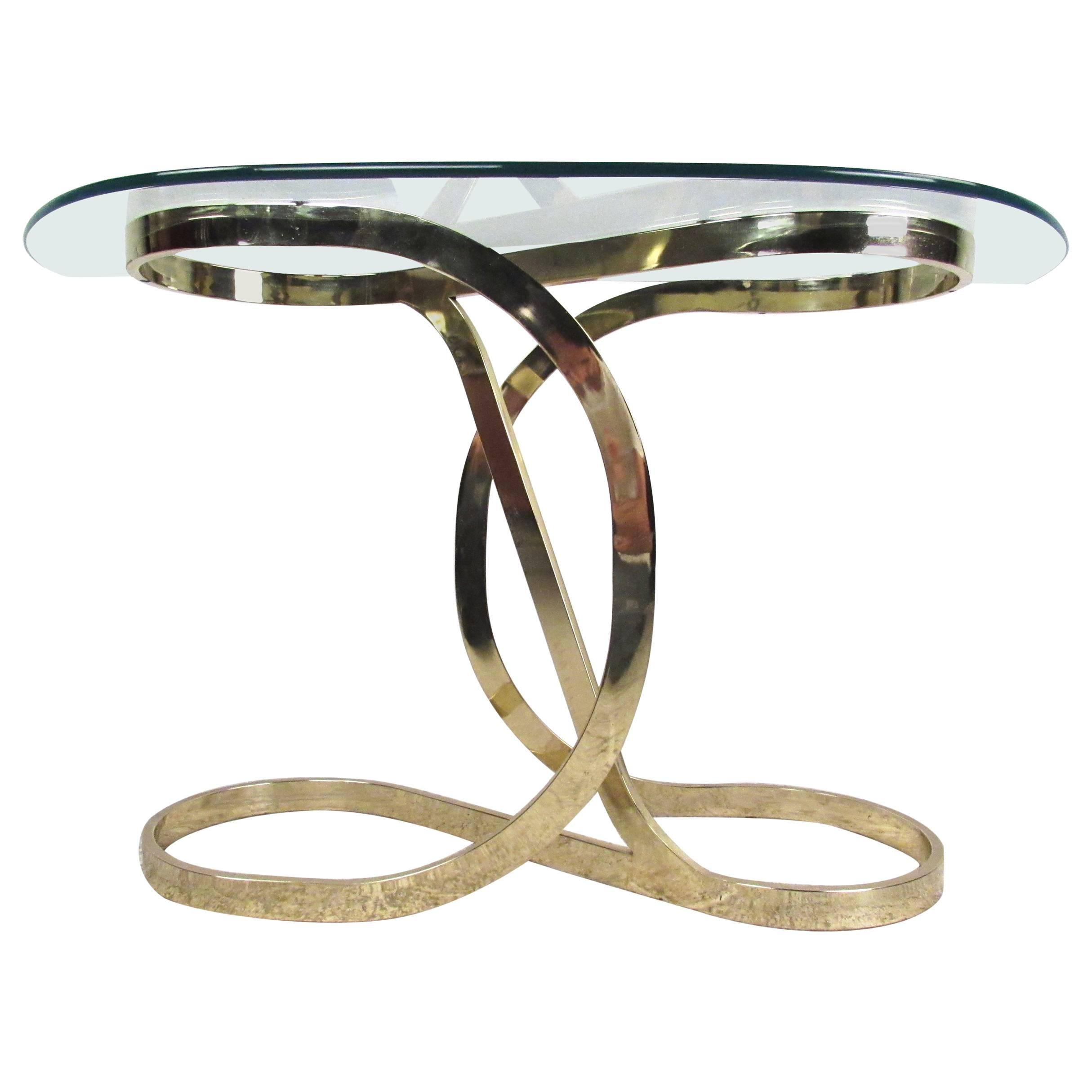 This unique vintage brass console table features an elegant sculpted infinity design with curved demilune glass top. Wonderful modern design makes this an ideal hall or entry table, perfect for luxurious home or business display. Please confirm item