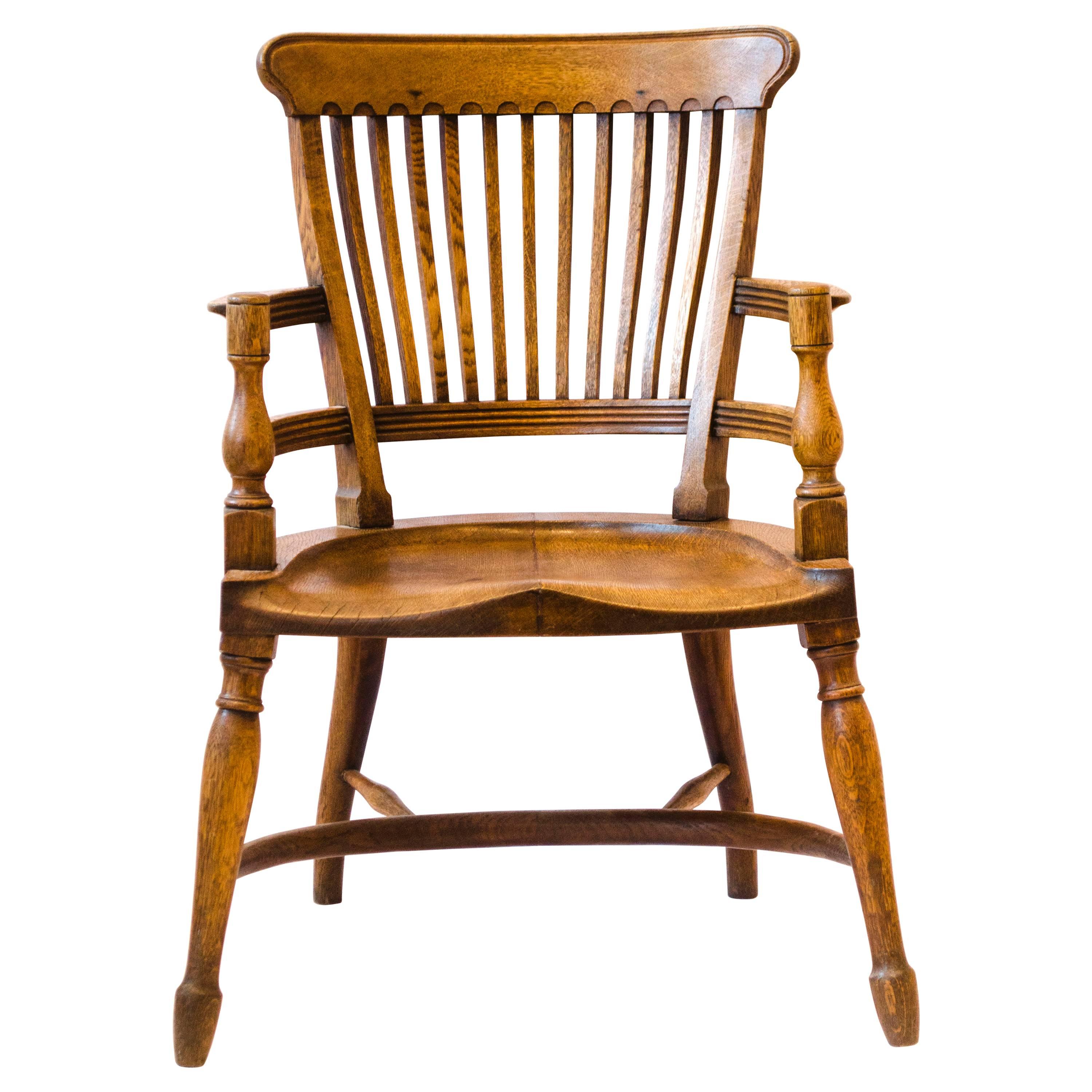 E W Godwin. Attr, An oak armchair with shaped back & a crinoline hoop stretcher For Sale