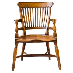 Used E W Godwin. Attr, An oak armchair with shaped back & a crinoline hoop stretcher
