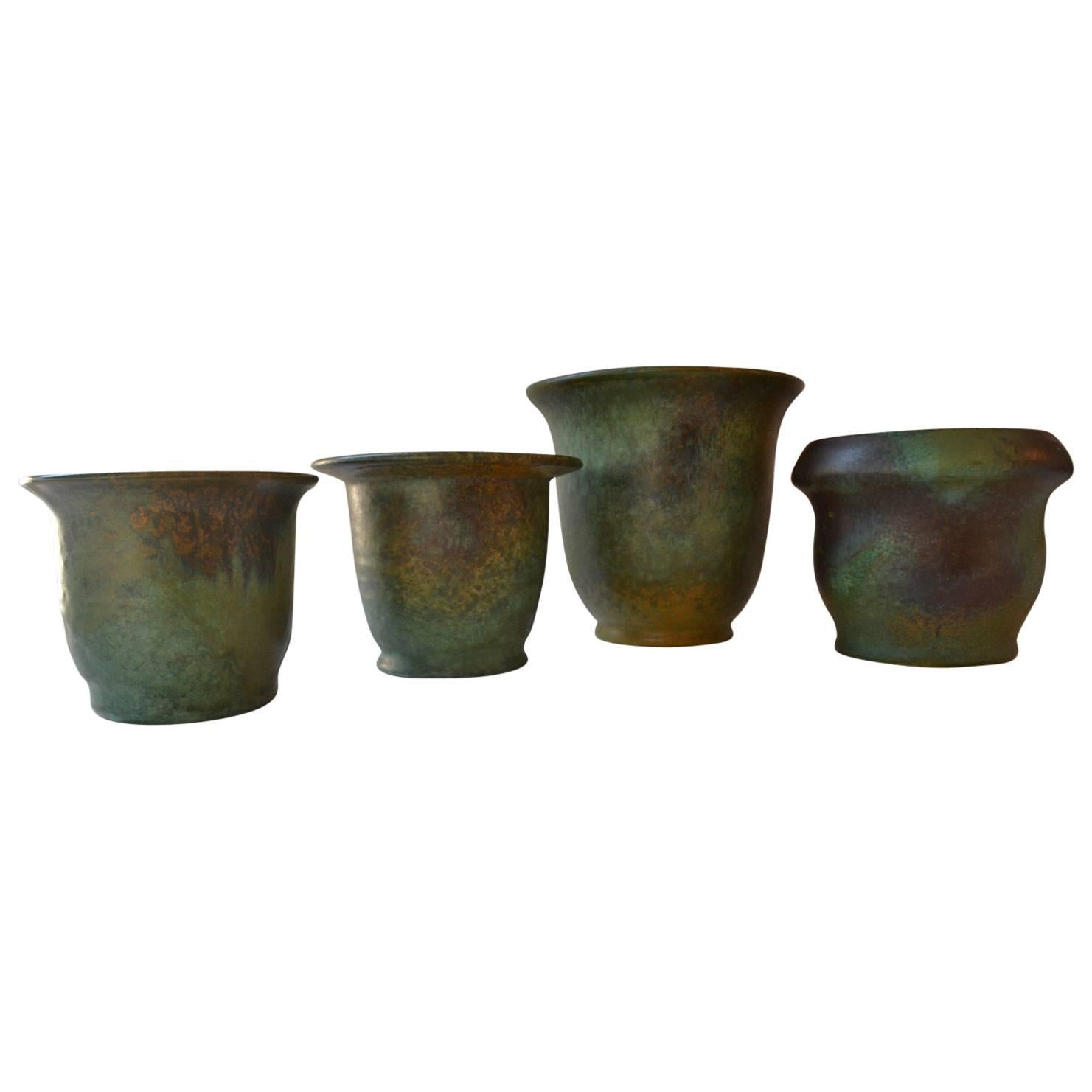 Group of four studio ceramic vases or flower pots in different sizes with subtile lively glaze like in oxidized copper, in typical Art Deco colors, signed by Dutch Frans van Katwijk.