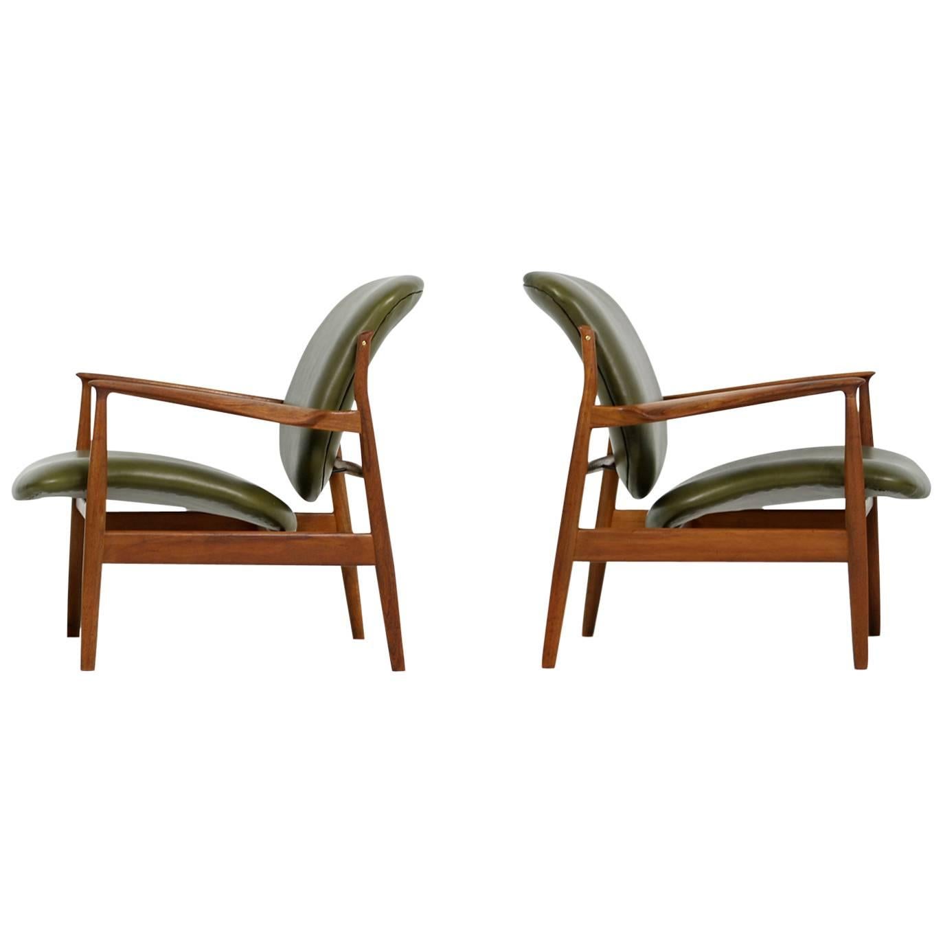 Beautiful pair of rare Finn Juhl, 1950s teak easy chairs, model FD 136 an early France & Daverkosen production, Danish modern design, new upholstery and covered with very high quality dark green real leather. Made in Denmark. Fantastic condition.