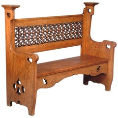 An Arts & Crafts Oak Settle by Liberty & Co with Mashrabiya turnings to the back